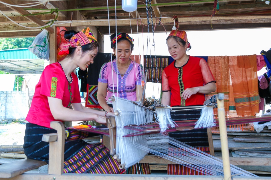 Chị em phụ nữ dân tộc Thái lựa chọn các sản phẩm dệt thổ cẩm. Ảnh: Công Kiên