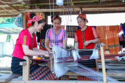 Chị em phụ nữ dân tộc Thái lựa chọn các sản phẩm dệt thổ cẩm. Ảnh: Công Kiên